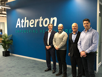 Representatives standing infront of the Atherton sign